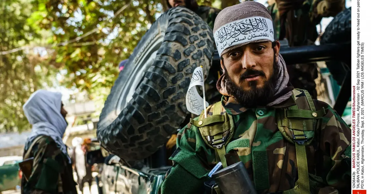 islamski bojownik w stroju moro na tle samochodu 