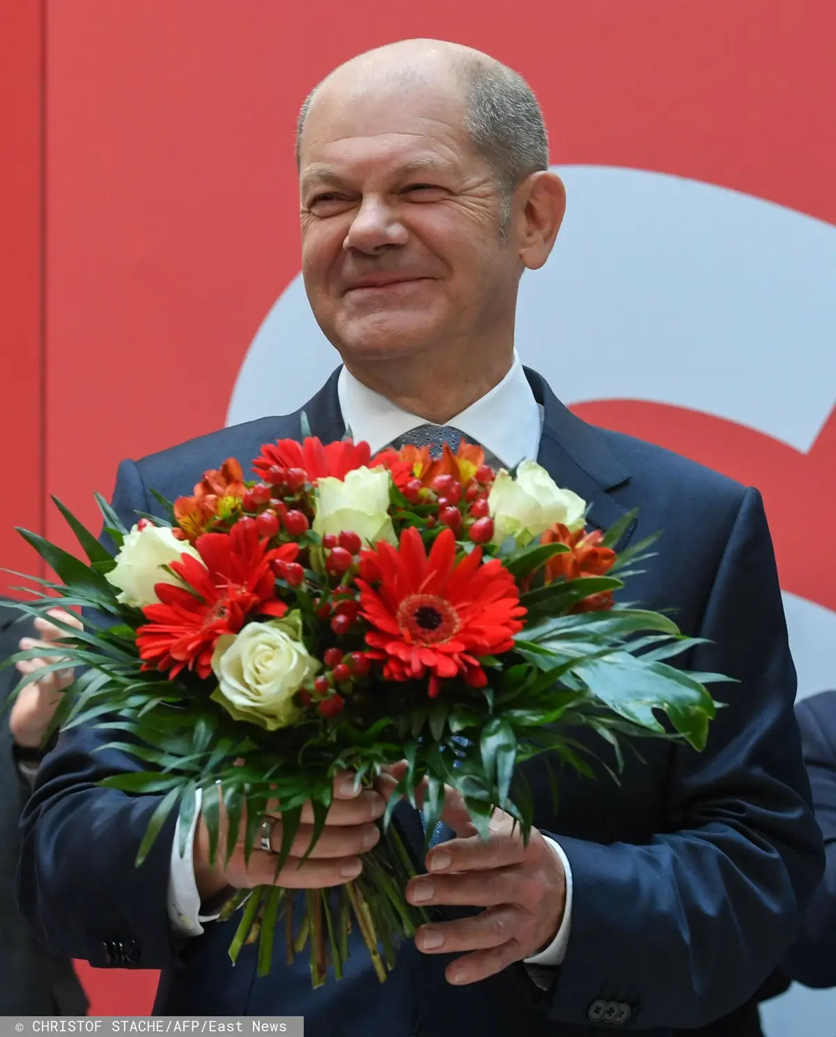Olaf Scholz z bukietem kwiatów podczas wyborów do Bundestagu 2021
