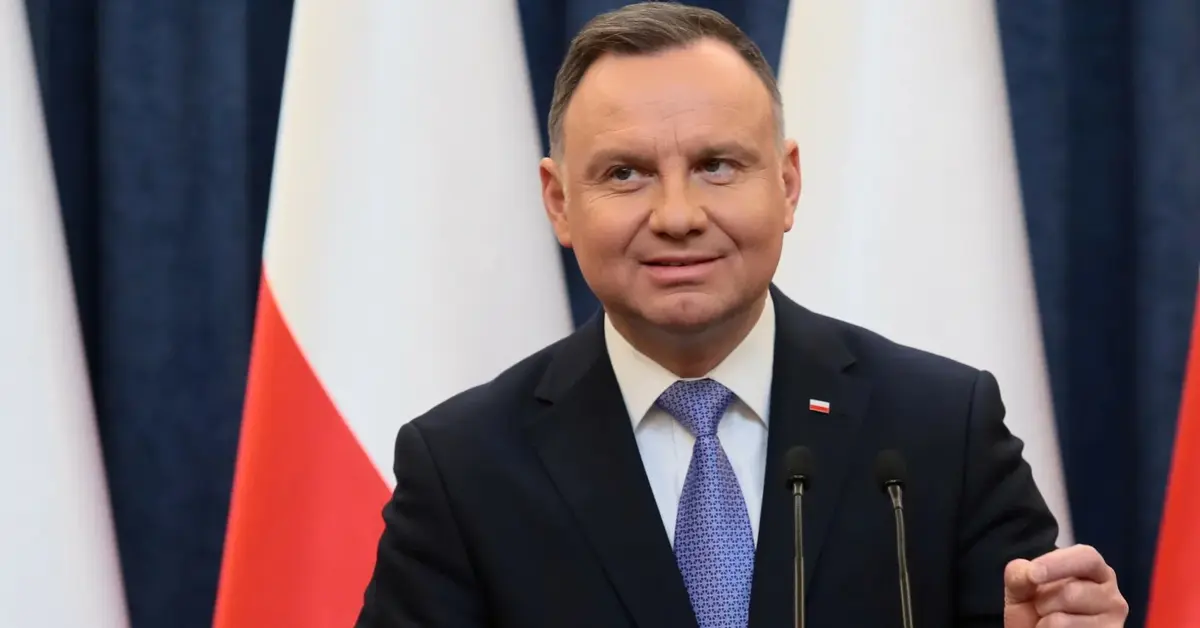 Andrzej Duda przemawia na tle biało-czerwonych flag