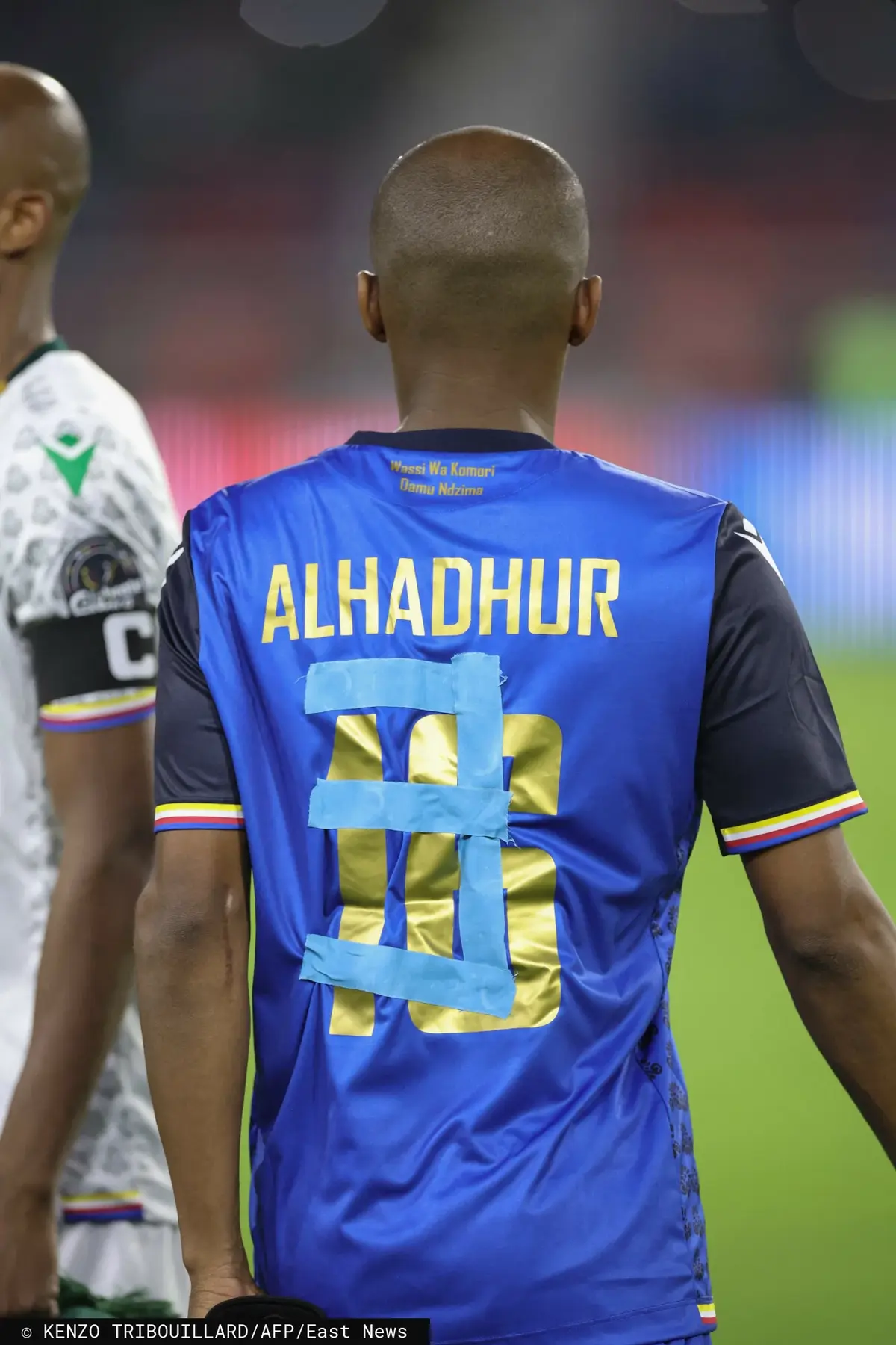 Piłkarz Komorów z naklejonym taśmą numerem.