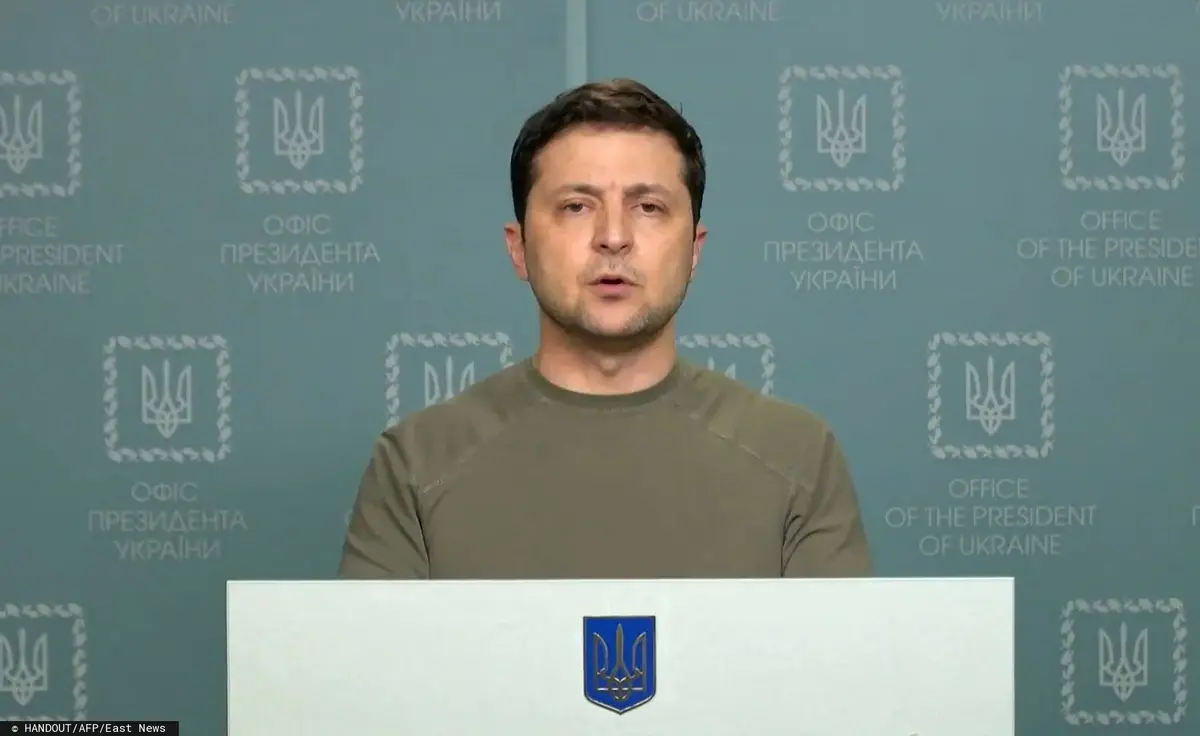 prezydent ukrainy zełenski stojący w zielonej koszulce za pulpitem