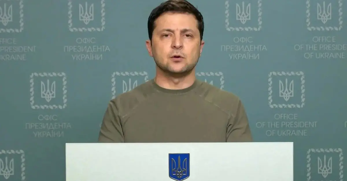 prezydent ukrainy zełenski stojący w zielonej koszulce za pulpitem