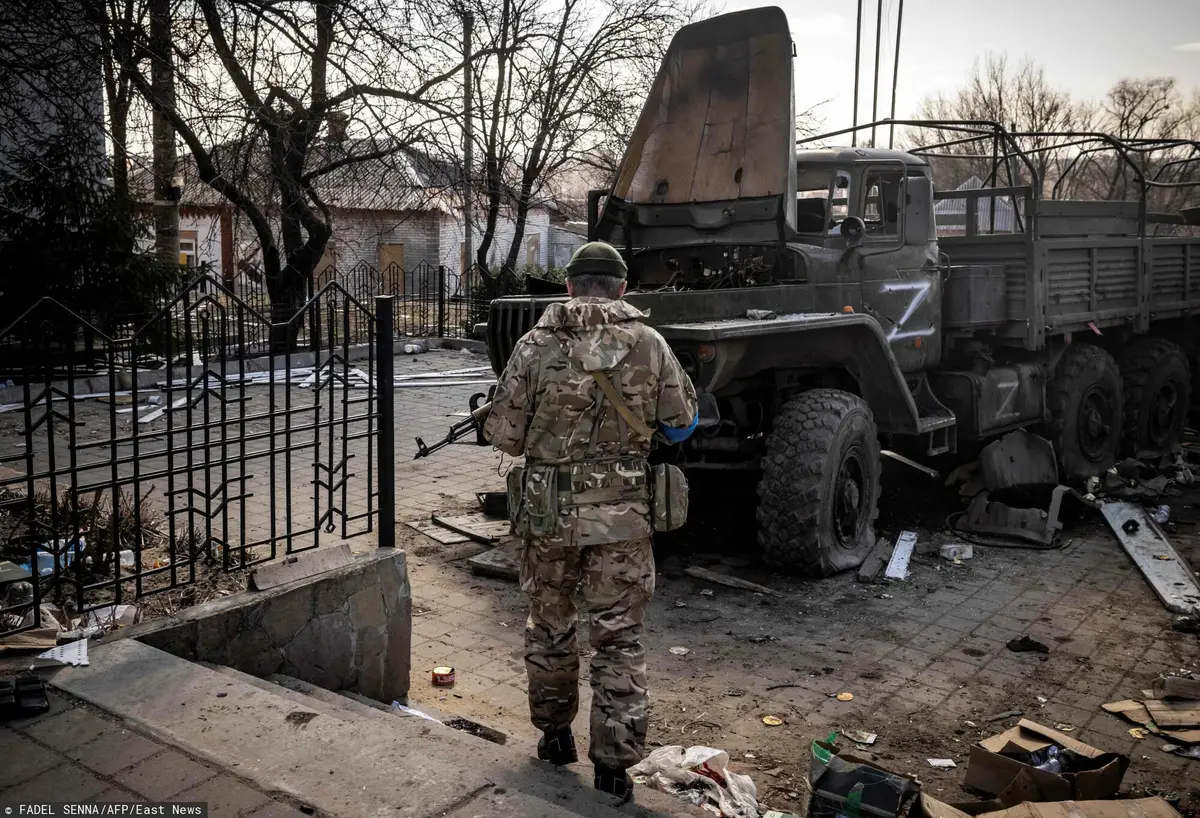 zniszczona rosyjska ciężarówka i ukraiński żołnierz
