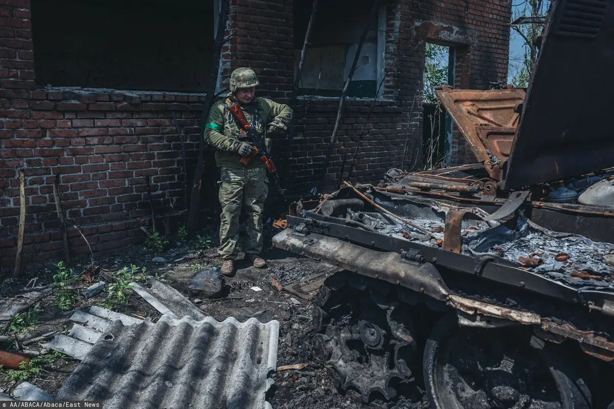 ukraiński żołnierz obok zniszczonego czołgu