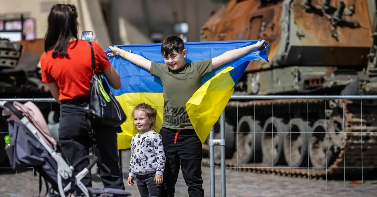dzieci pozujące z ukraińską flagą