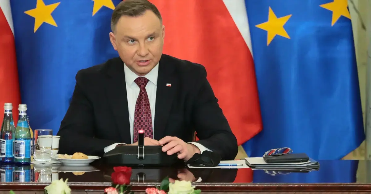 Andrzej Duda przemawia, w tle flagi Polski i UE