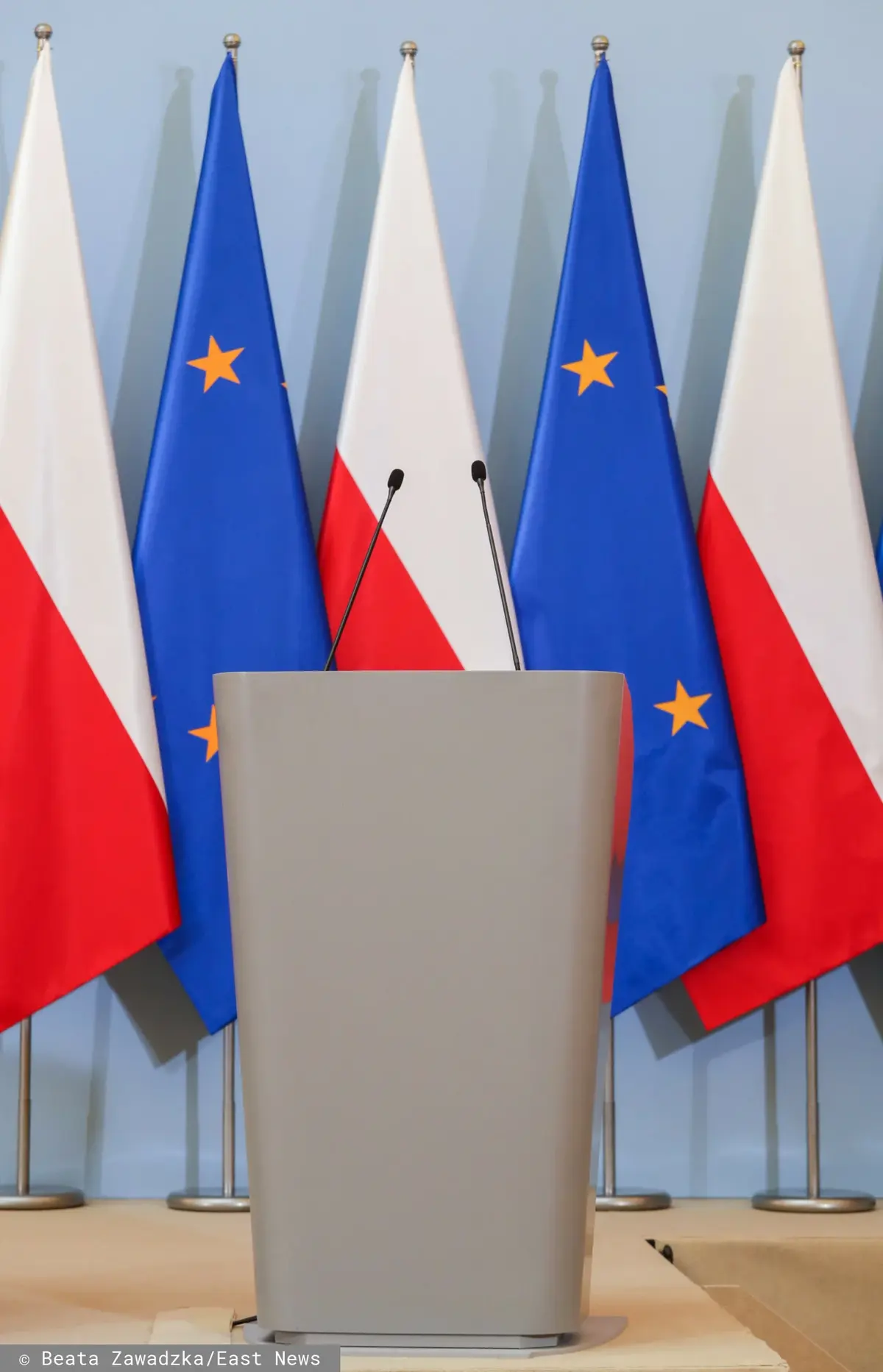 Flagi Polski i Unii Europejskiej w sali, gdzie odbywa się konferencja prasowa