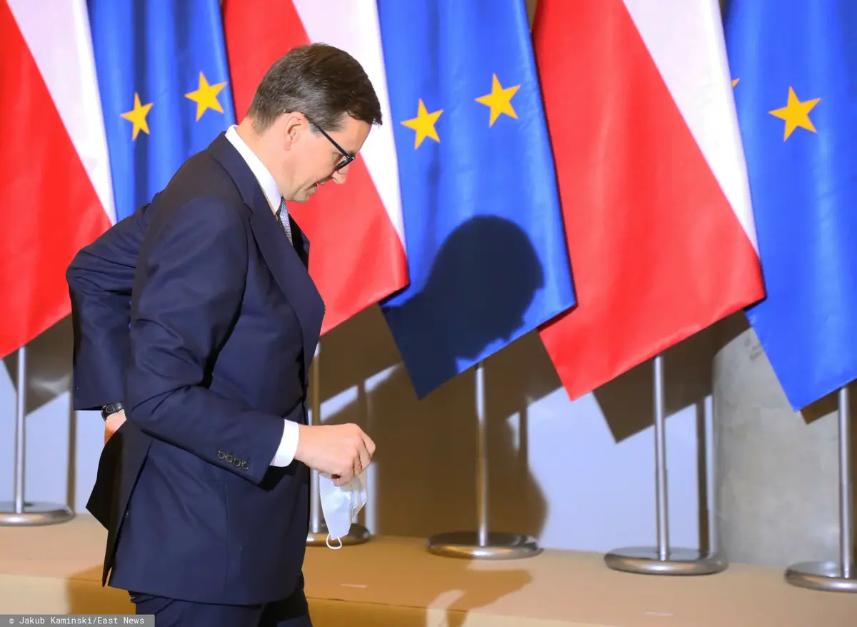 Mateusz Morawiecki na tle flagi Polski i Unii Europejskiej