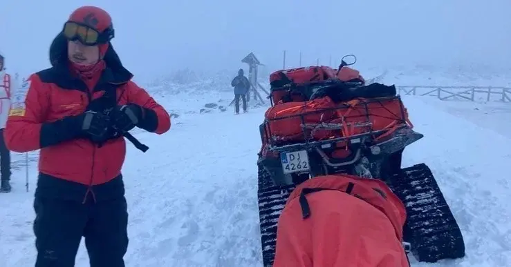 Ratownik GOPR w trakcie akcji stoi na śniegu obok quada