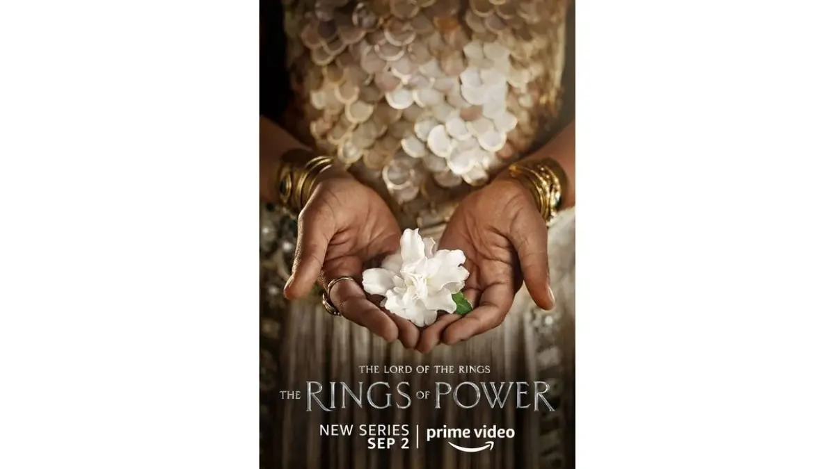 Plakat "Pierścienie władzy": dłonie z białym kwiatem
