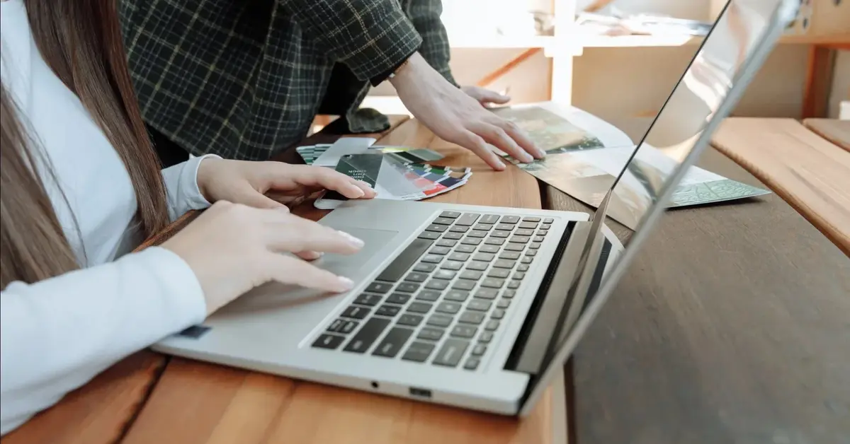 Dwie osoby pracują przy laptopie