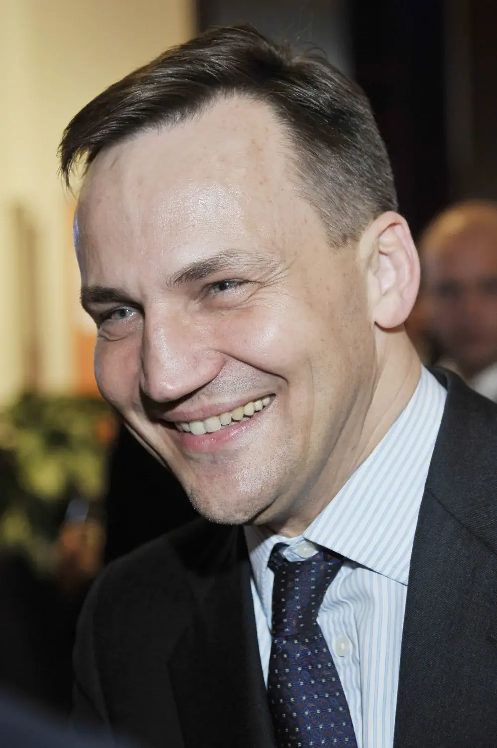 Radosław Sikorski uśmiecha się
