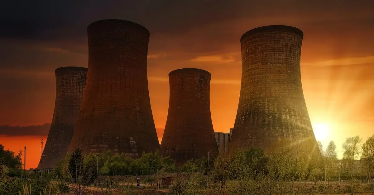 Kominy elektrowni jądrowej na tle zachodzącego słońca