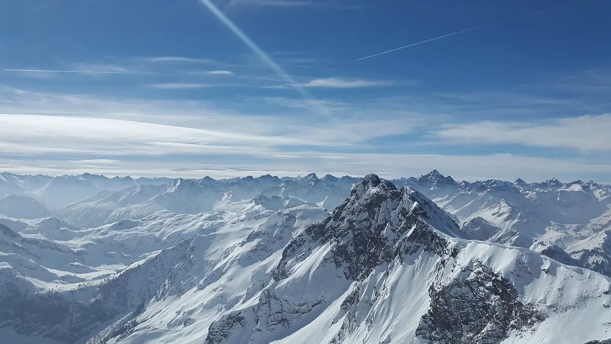 ośnieżone szczyty Alp i błękitne niebo nad górami 