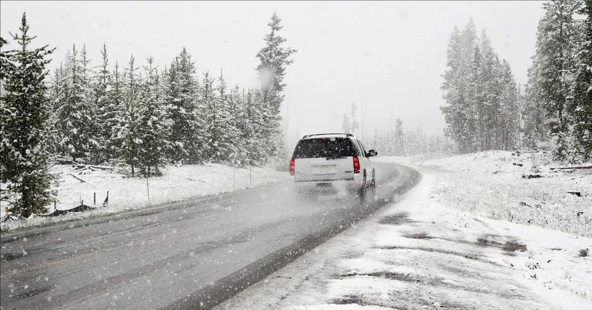 samochód jadący zaśnieżoną drogą