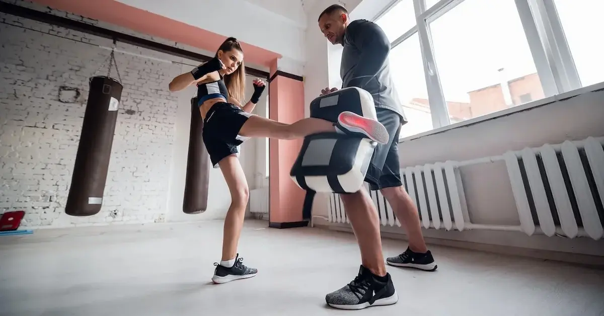 Kobieta na sali treningowej trenuje kopnięcia