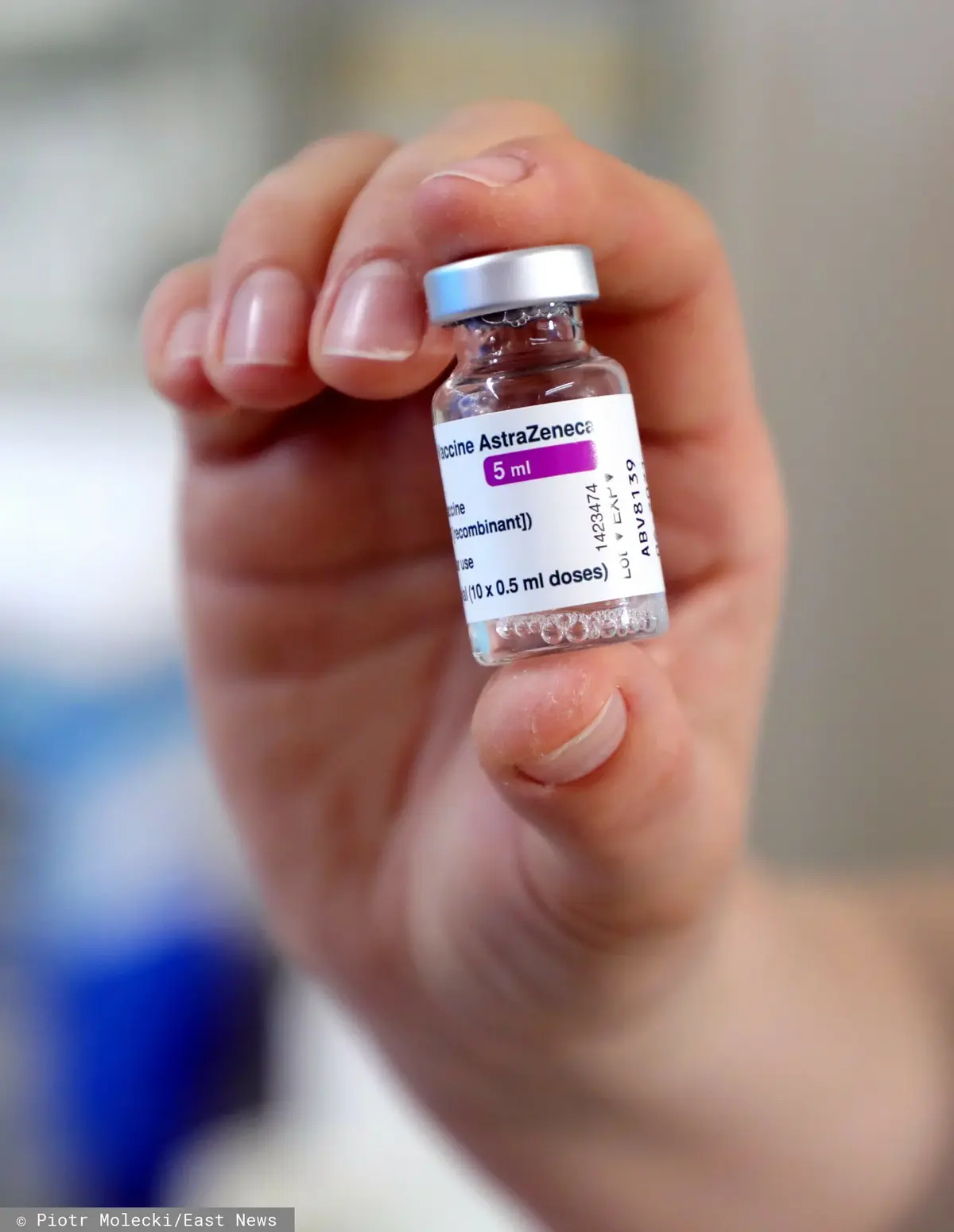 Szczepionka przeciwko COVID-19 trzymana w dłoni