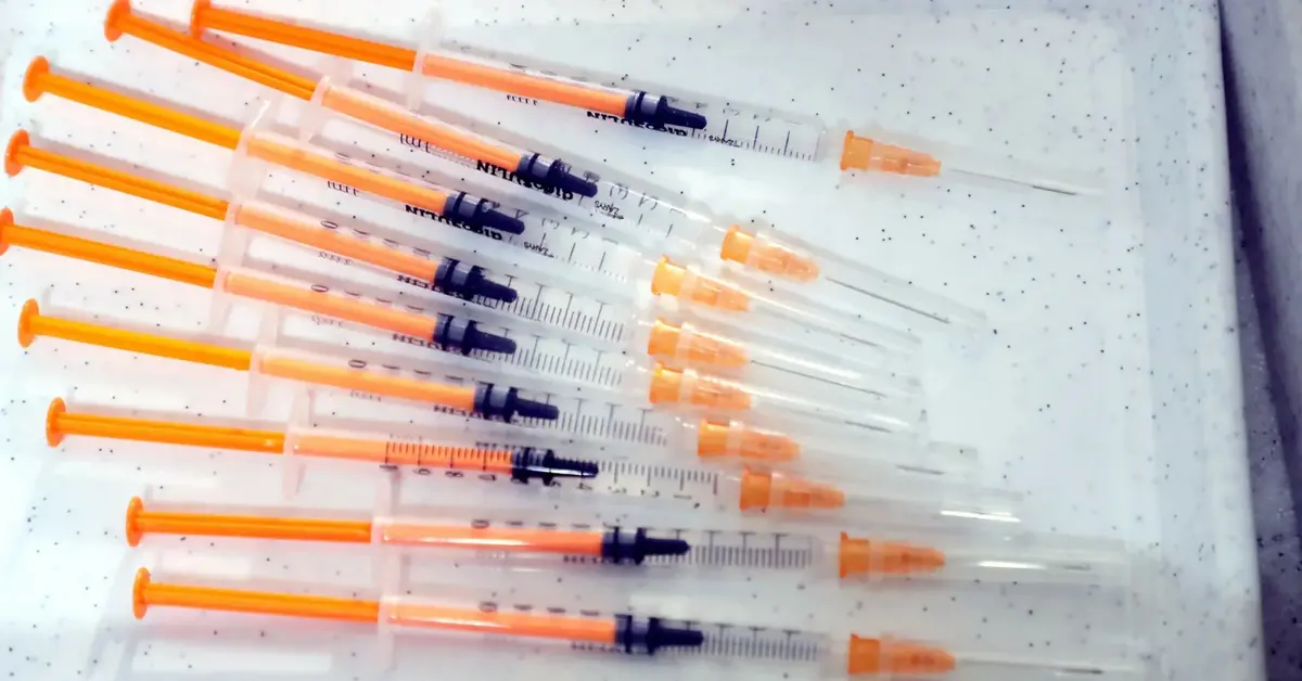 Strzykawki ze szczepionką leżące na stole