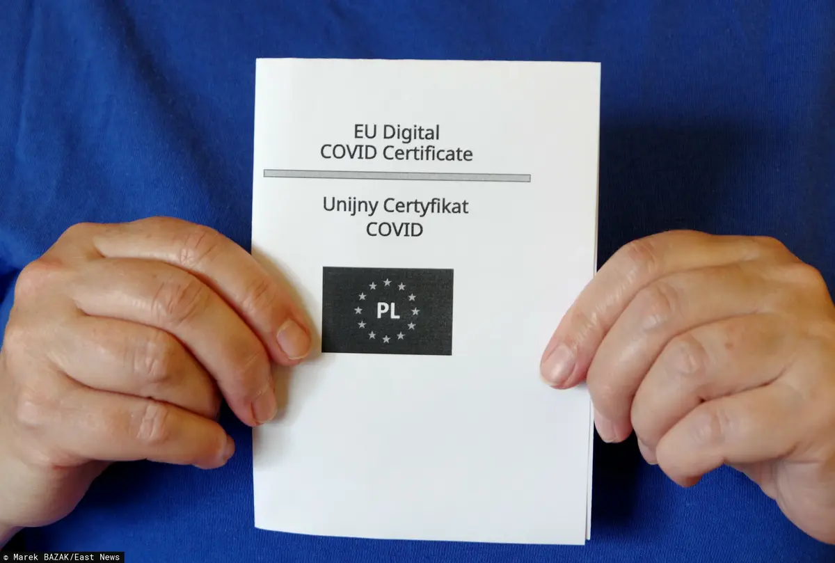 Unijny Certyfikat COVID trzymany w rękach