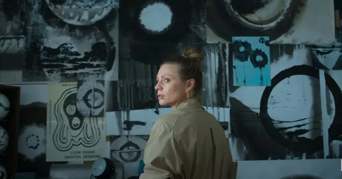 Kadr z "Zachowaj spokój" - odwrócona bokiem kobieta na tle ściany