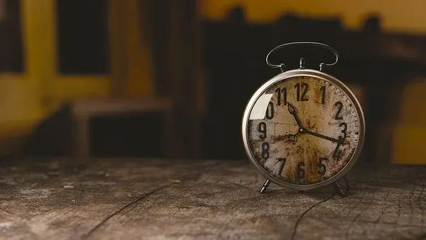 Zniszczony zegar, stojący na starym stole